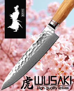 Wusaki kitchen knife - Damascus chef's knife with olive wood handle in front of a cherry blossom background